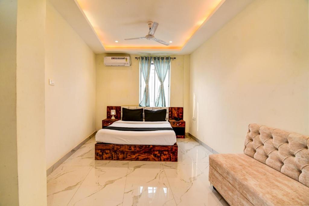 a bedroom with a bed and a couch at Collection O The Hastings Club in Kolkata