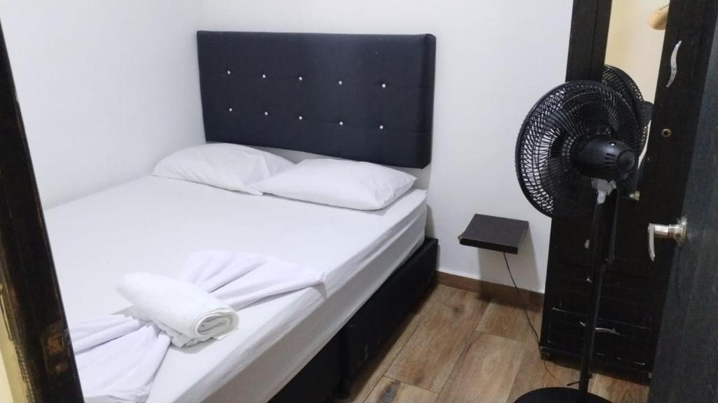 a small bedroom with a bed and a fan at Apartamentos Acogedores Laureles in Medellín