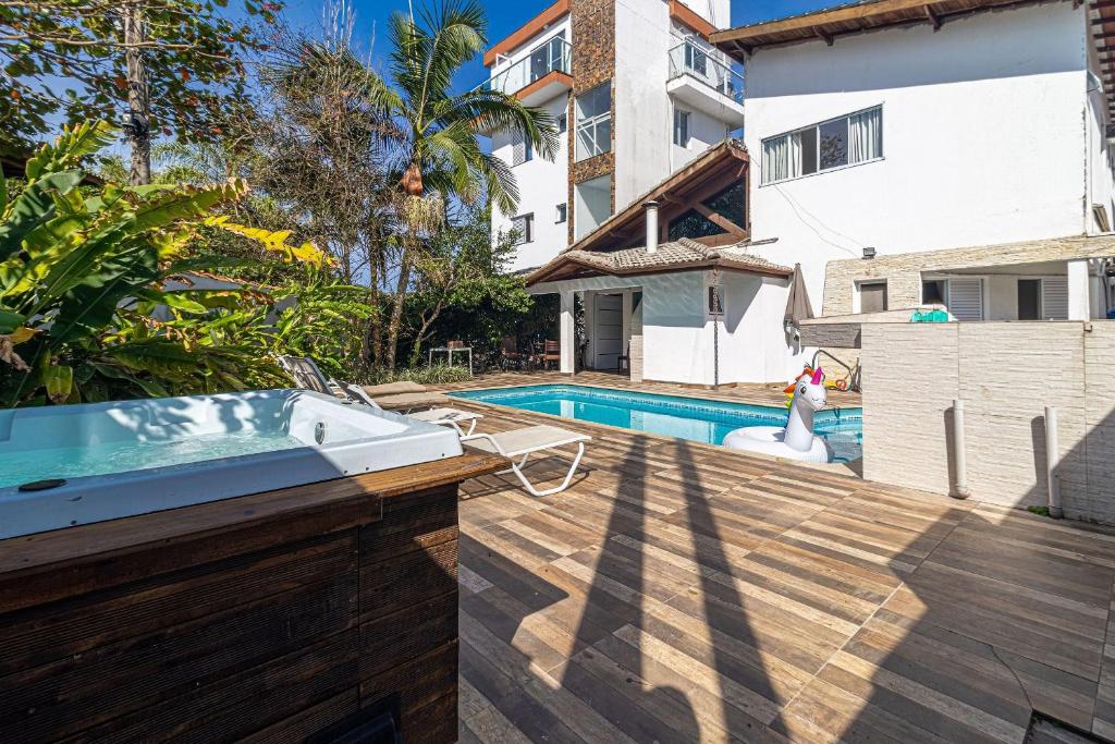 an outdoor swimming pool with a villa and a swimming pool at Casa com Piscina climatizada , Jacuzzi 4 Quartos. in Bertioga