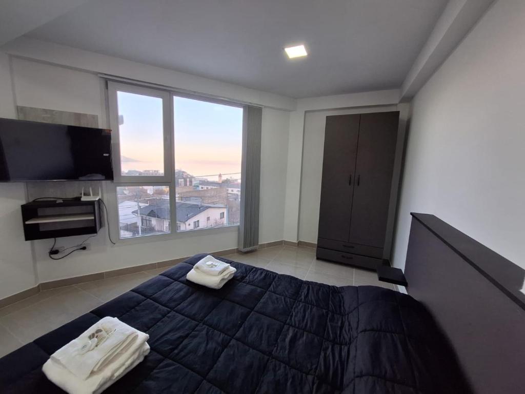 Un dormitorio con una cama grande y una ventana grande. en Edificio Eclipse, en Ushuaia
