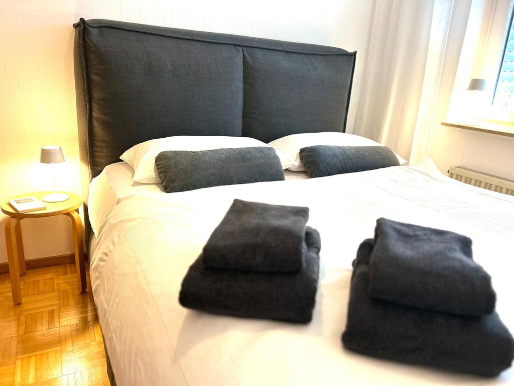 Un dormitorio con una cama grande con toallas negras. en Japandi-Style in Dortmund mit Stellplatz, Balkon, en Dortmund
