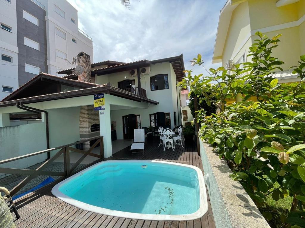 una piscina su una terrazza accanto a una casa di Cód 9 · Casa aconchegante á 300m do mar! a Governador Celso Ramos