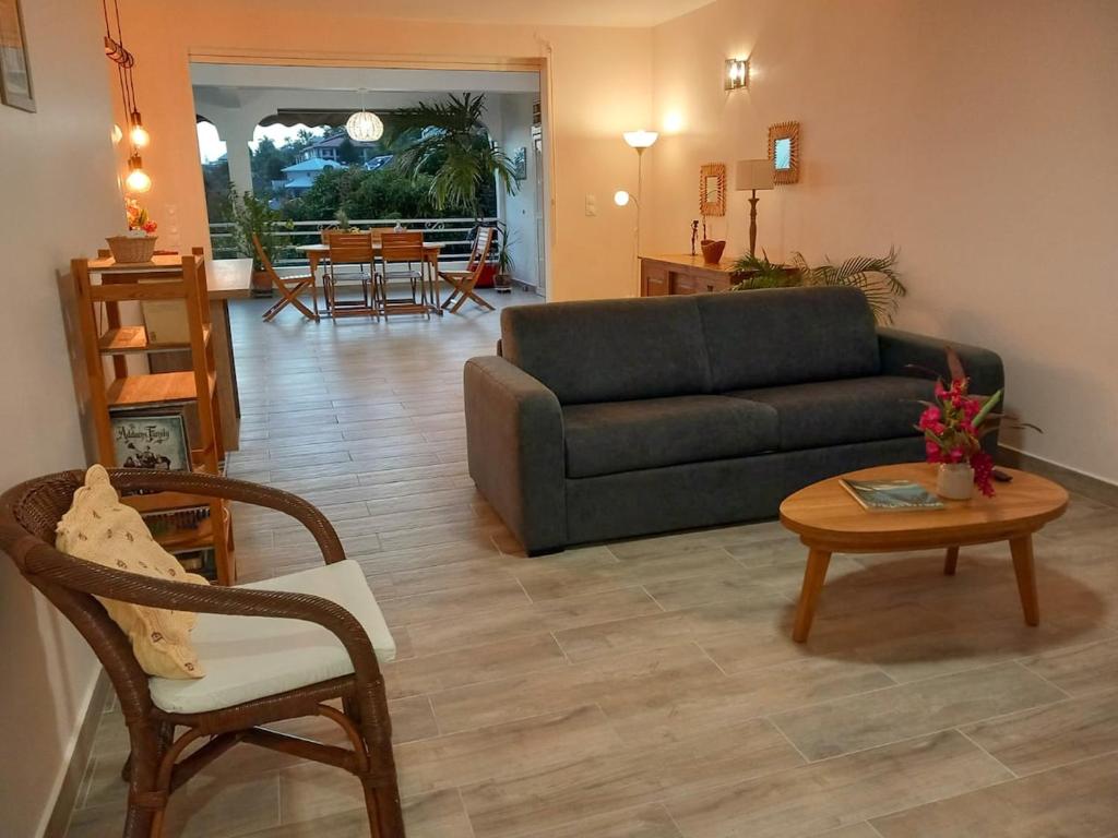 a living room with a couch and a table at Terrasses ouvertes sur la mer in Schœlcher