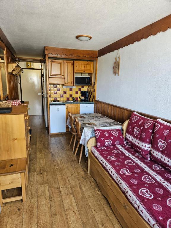 a kitchen with a couch and a table in a room at Les Menuires sur les pistes in Les Menuires