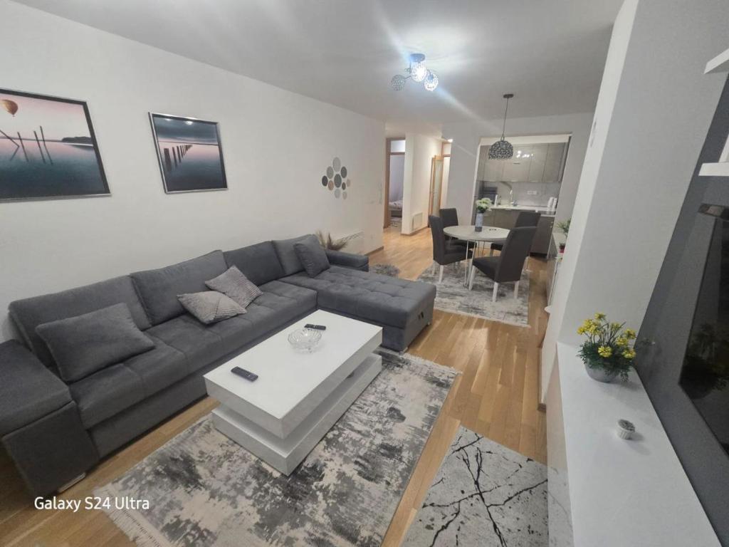 a living room with a couch and a table at AiM apartman Bjelasnica in Bjelašnica