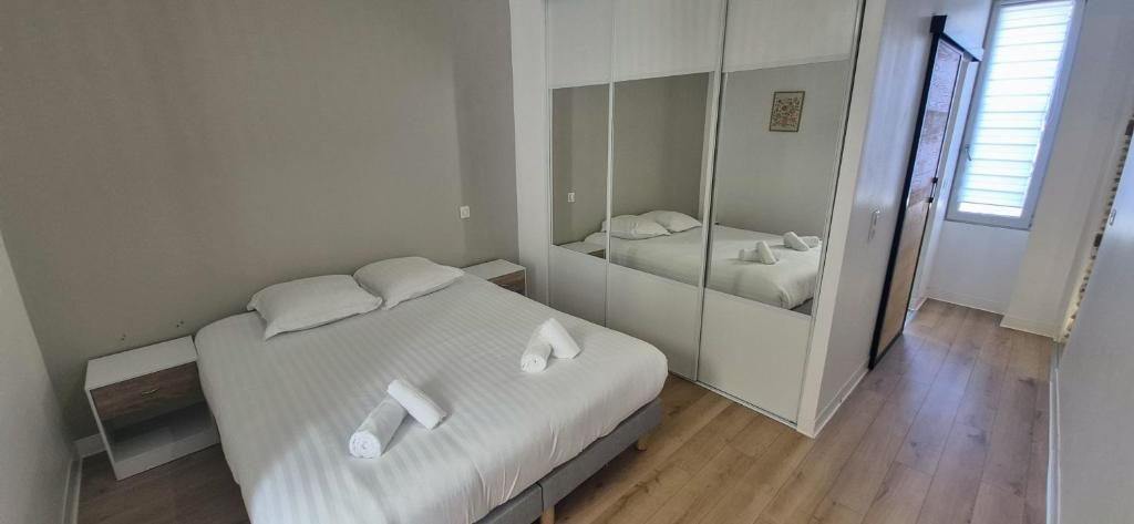 a bedroom with a white bed and a mirror at Escapade Pau Appart moderne avec terrasse privée in Pau