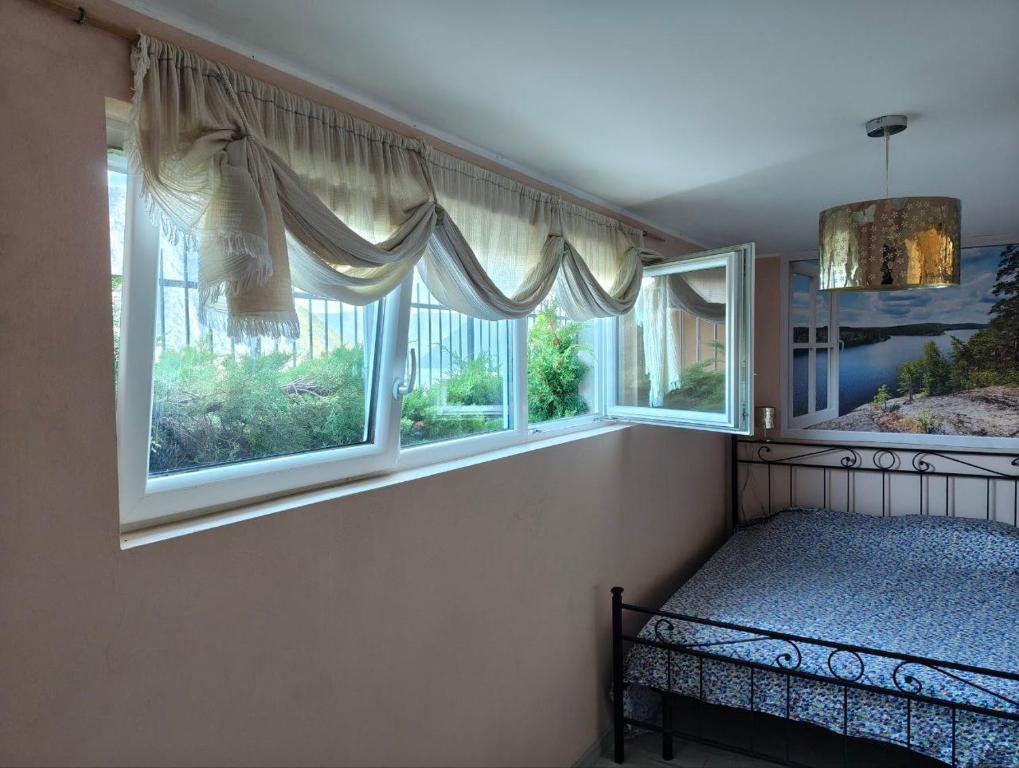 a bedroom with two windows and a bed in it at Appartamento con sauna e home cinema in Colonno