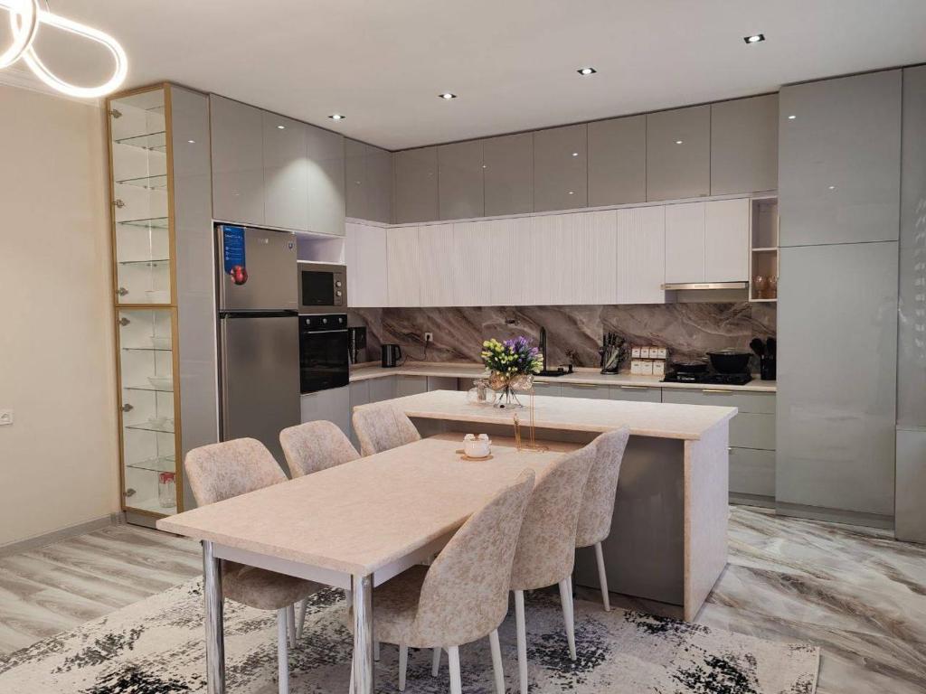 a kitchen with a table and chairs in a kitchen at Snowlight Studio in Toshkent-Passajir Bekati