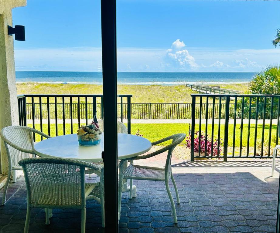Una mesa y sillas en un patio con vista al mar. en The Seahorse, a 2bed beach paradise in Fernandina Beach, swimming pool!, en Fernandina Beach