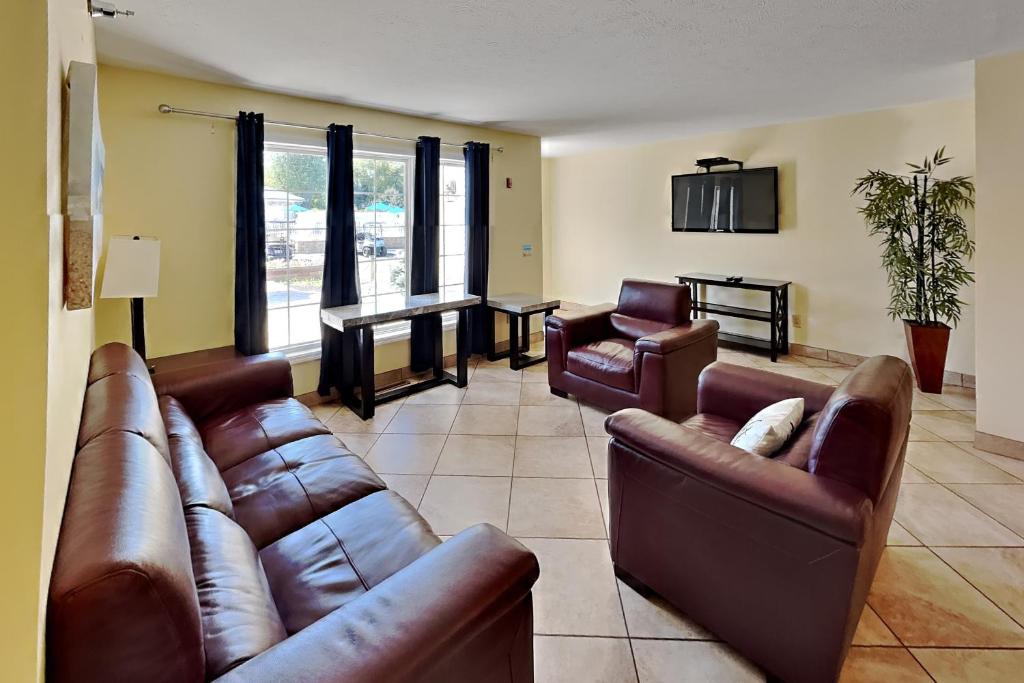 a living room with leather couches and a table at Put-in-Bay Poolview Condo #3 in Put-in-Bay