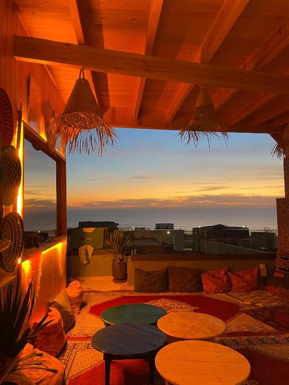 a patio with tables and a view of the ocean at imsouane bleu bay house in Imsouane