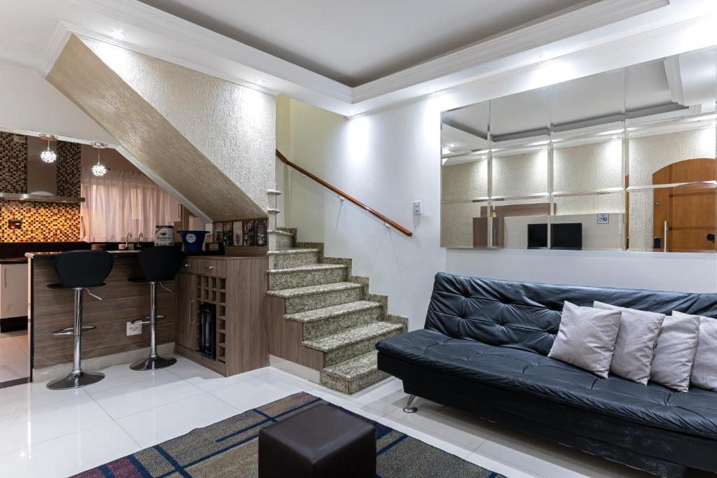 a living room with a couch and a staircase at Tatuapé , garagem e ar condicionado in Sao Paulo
