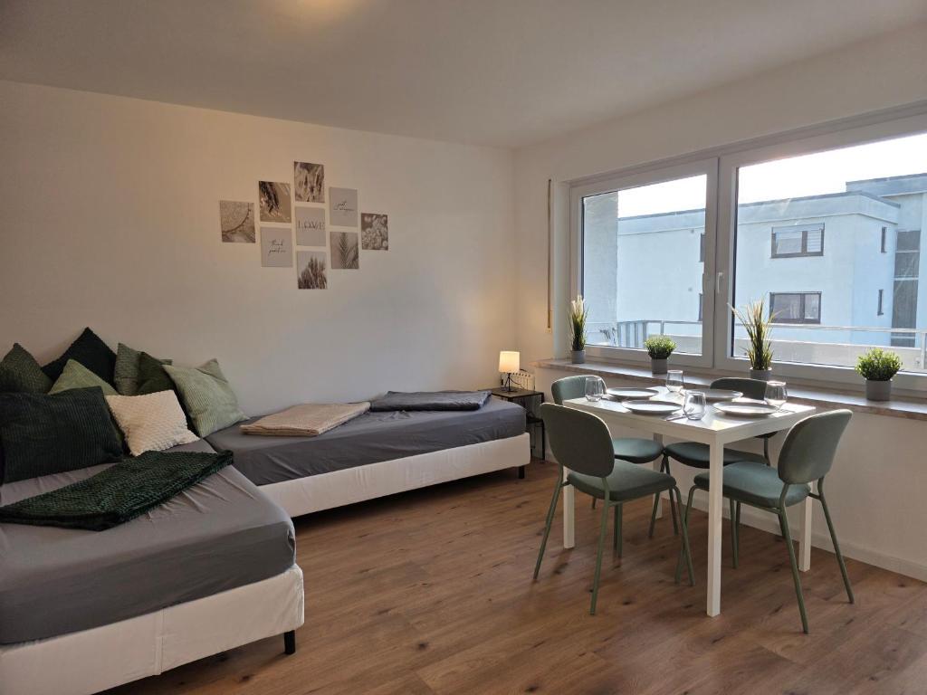 a bedroom with two beds and a table and chairs at Gemütliches Apartment mit Balkon - Hans NU2 in Neu Ulm