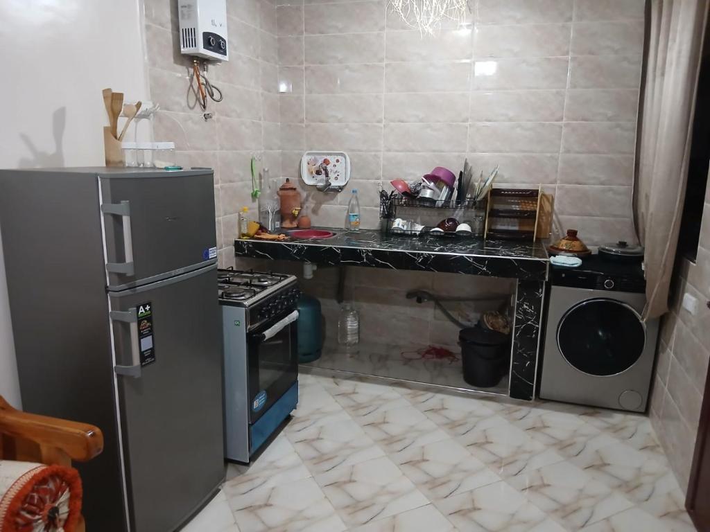 een keuken met een aanrecht, een fornuis en een koelkast bij Zina résidence in Aourir