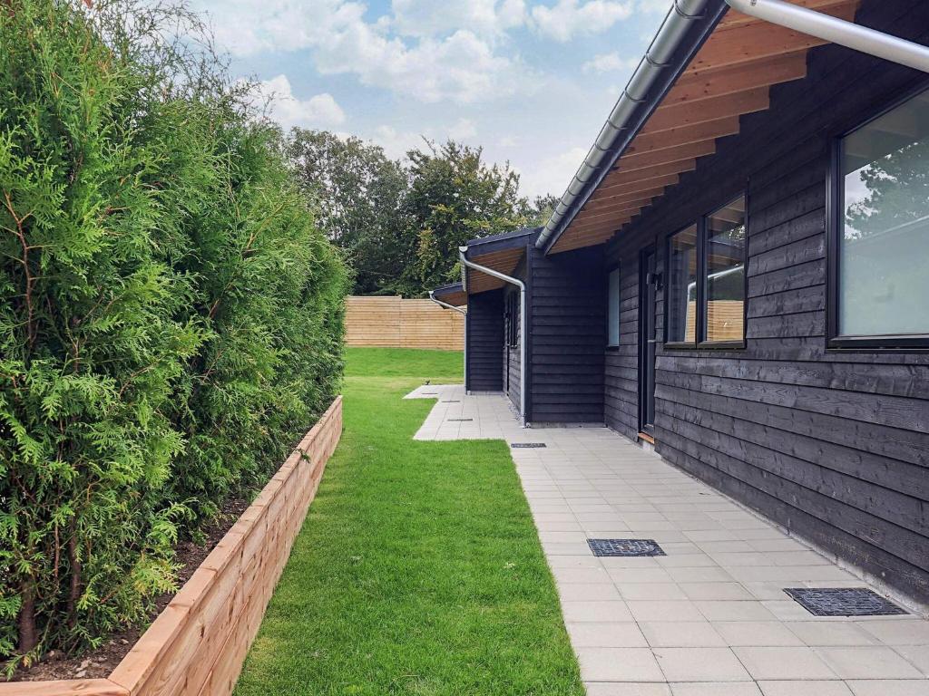 a house with a walkway next to a yard at Holiday home in a park in Gilleleje in Gilleleje