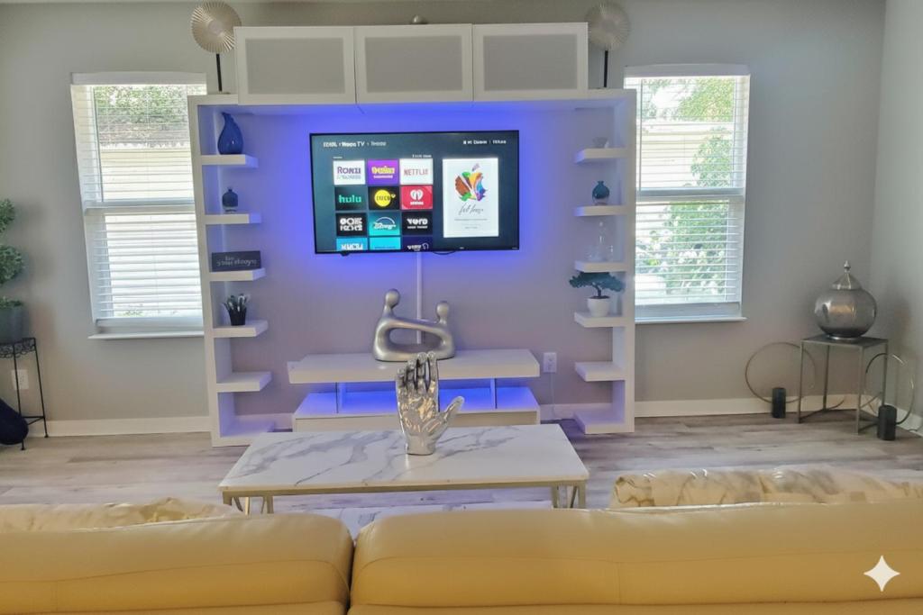 a living room with a couch and a tv on a wall at Welcome to Tranquility House in Tampa