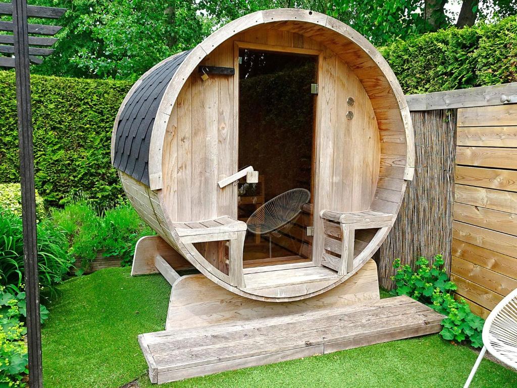 a small wooden hobbit house in a garden at Kolibrie in Dirkshorn