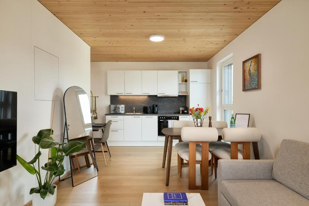 a kitchen and living room with a couch and a table at VORALIVING - Modernes Neubau Apartment Toplage - Business & Urlaub - WLAN, 24 7 Check-in in Dornbirn