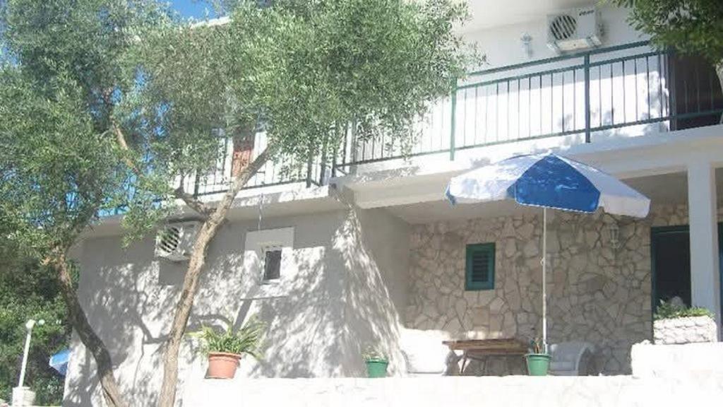 a house with a blue and white umbrella in front of it at Apartments with parking space Trpanj, Peljesac - 15976 in Trpanj
