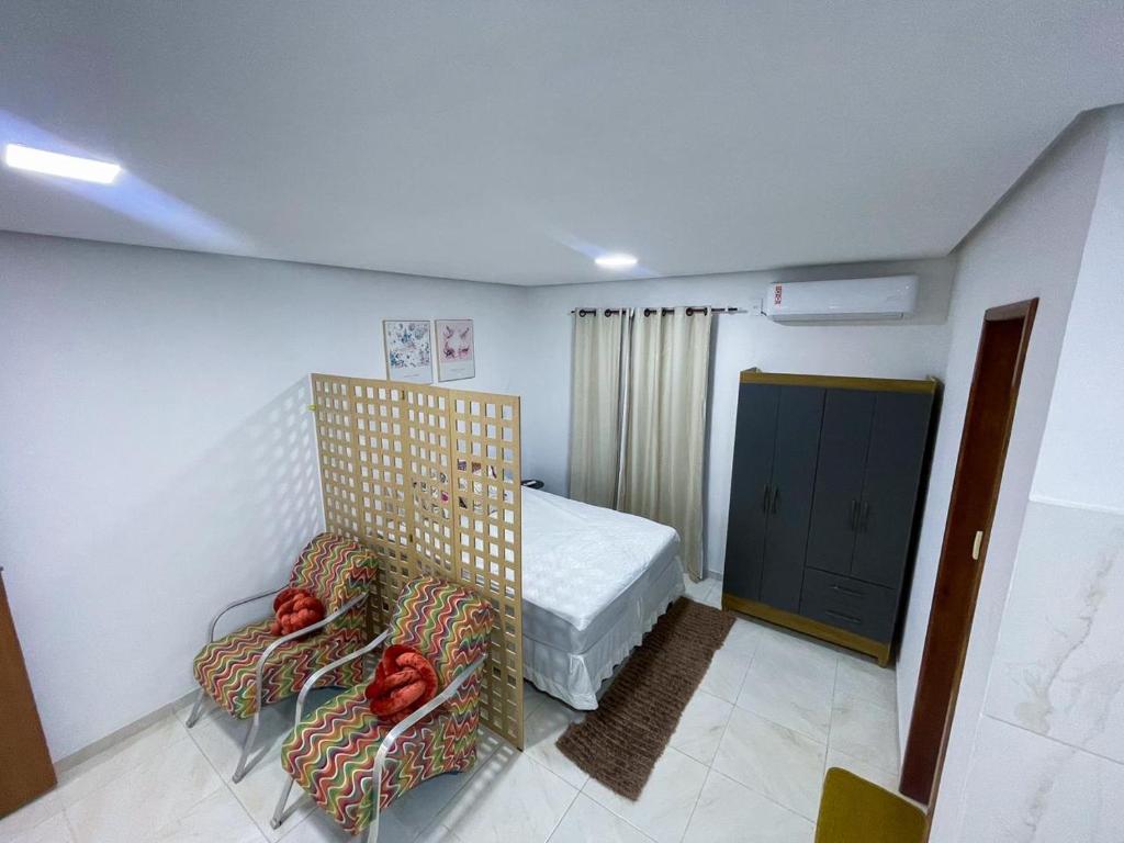 Santa InêsにあるApto aconcheganteのベッドルーム1室(ベッド1台、椅子2脚付)