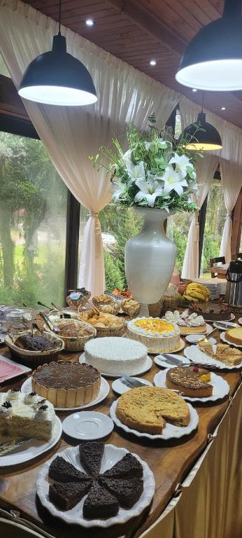 een tafel met veel verschillende soorten gebak en taarten bij Pousada suite avencal in Urubici