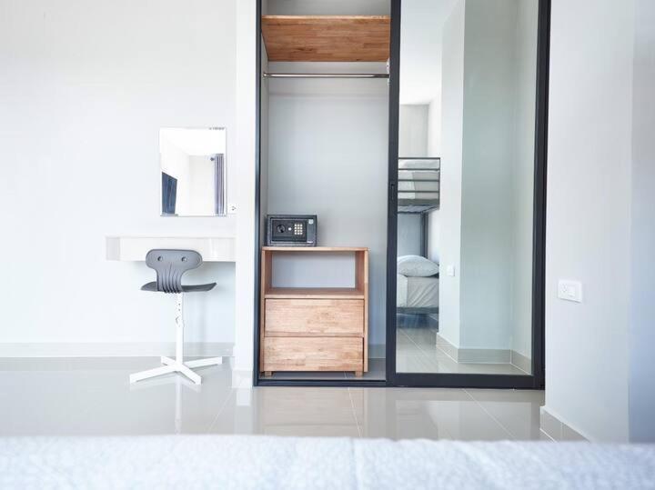 a room with a mirror and a chair in it at Family room in Baan Pakdi Pattaya in Pattaya Central