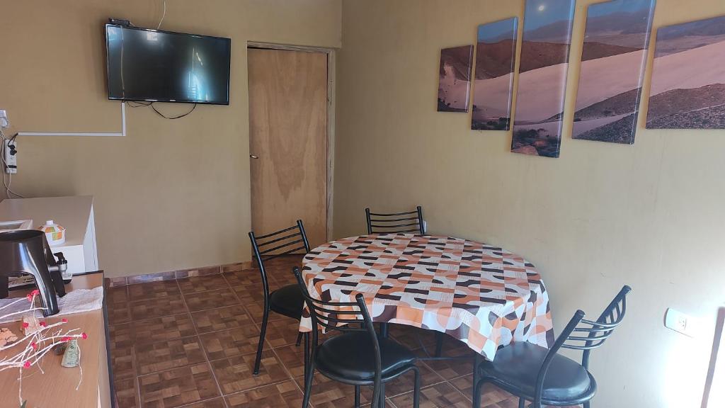 a room with a table and chairs and a television at Depto Emma in Fiambala