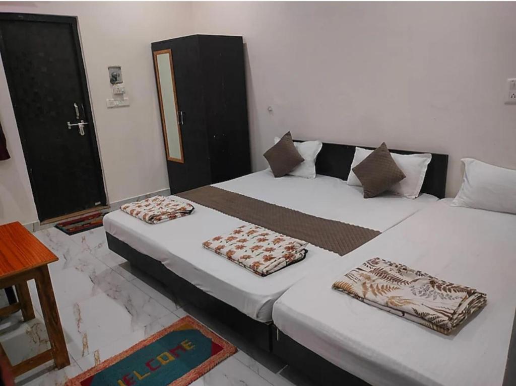 two beds in a room with white walls at Shree Rameshwaram Guest House Near Ram Mandir Ayodhya Dham in Ayodhya