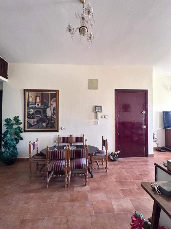 Una sala de estar con una mesa y sillas y una lámpara de araña. en Appartement B 10, en Fez