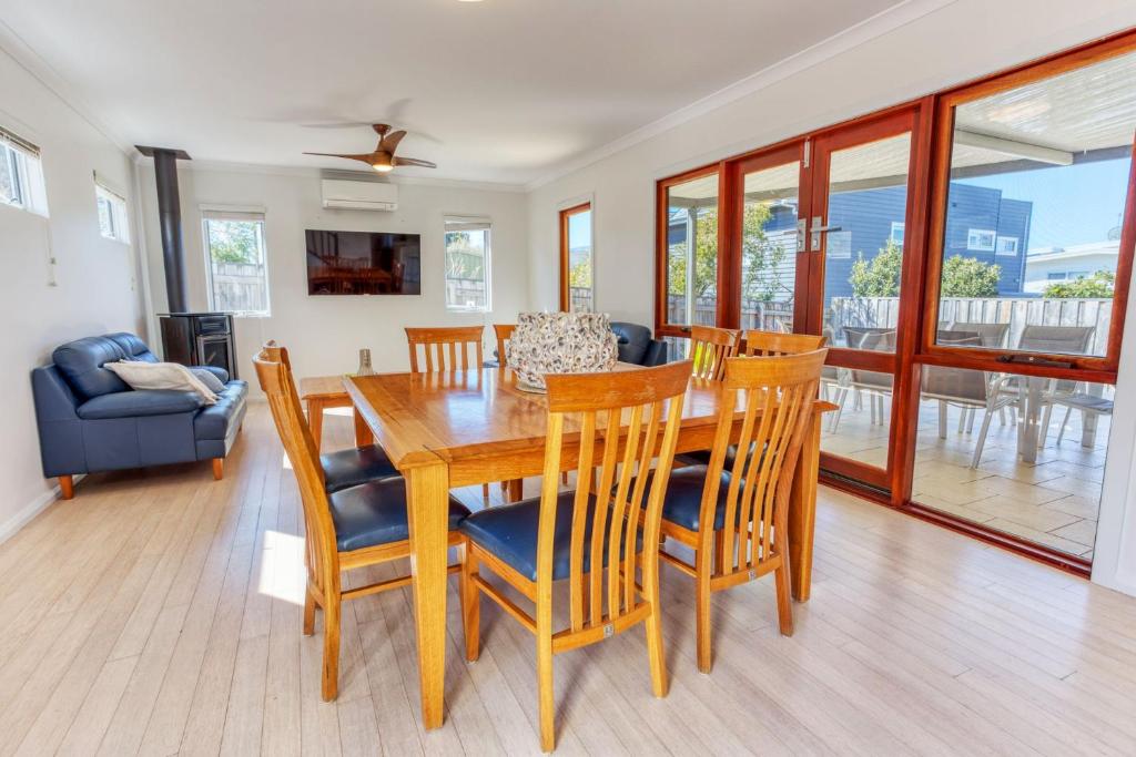 ダンズボローにあるTurner Street Holiday House, Dunsboroughのダイニングルーム、リビングルーム(木製テーブル、椅子付)