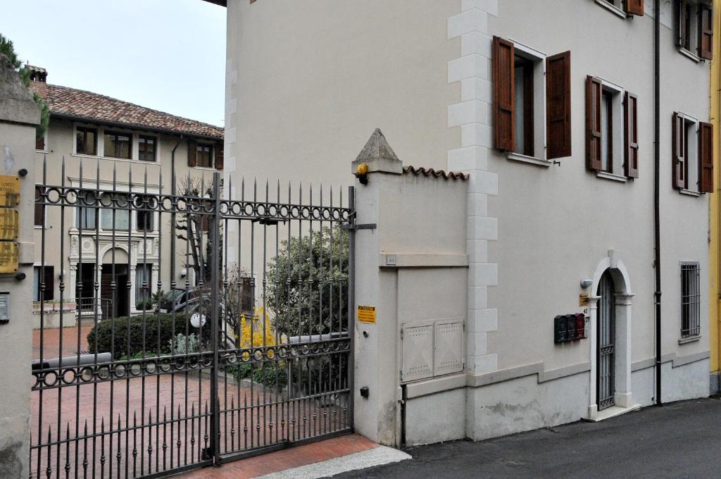 a gate to a white building with a fence at Palazzina Gelsomino in Desenzano del Garda