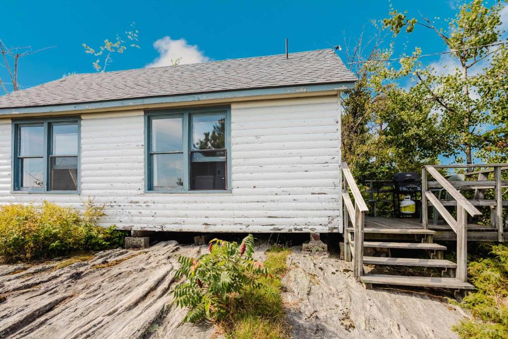 une petite maison blanche sur une colline sablonneuse dans l'établissement 2-Bedroom Cottage with Stunning View - Rockwood #6, à Dillon