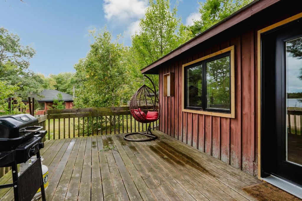 a porch with a red chair on a wooden deck at 2-Bedroom Cottage #2 - Sand Bay in Dillon
