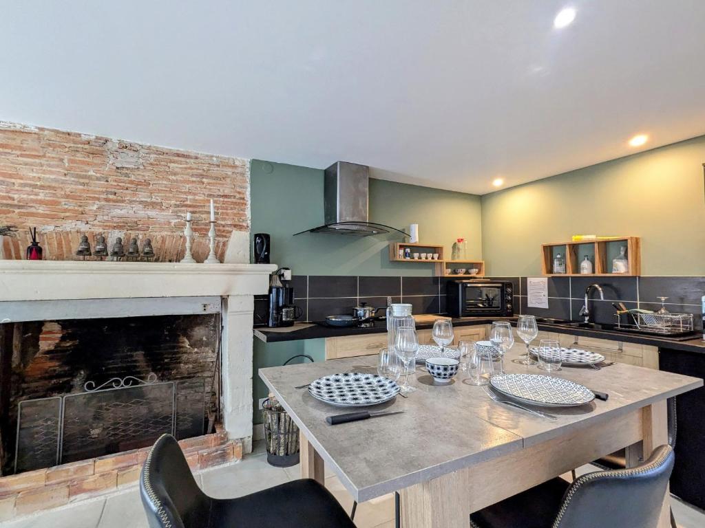 une cuisine avec une table en bois et une cheminée dans l'établissement Evasion et nature près de Châteauroux, logez au cœur du Berry - FR-1-591-763, à Meunet-Planches