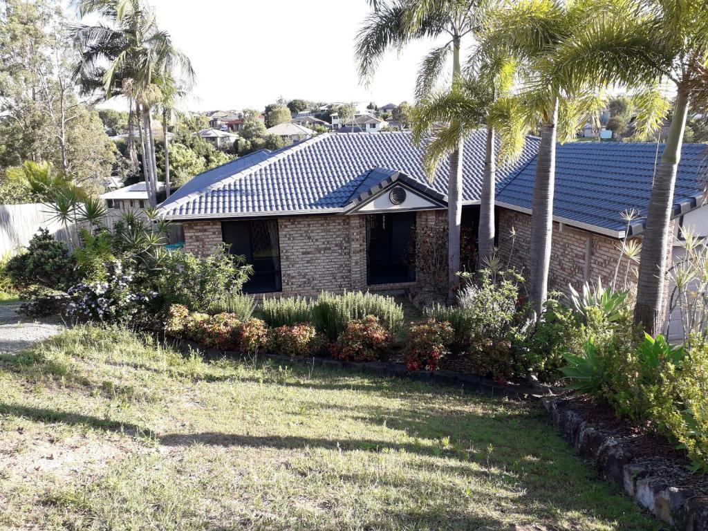 a house with a blue roof and palm trees at Lovely, bright single bedroom, private bathroom, coffee beakfast, relax, near shopping Malls in Collingwood Park