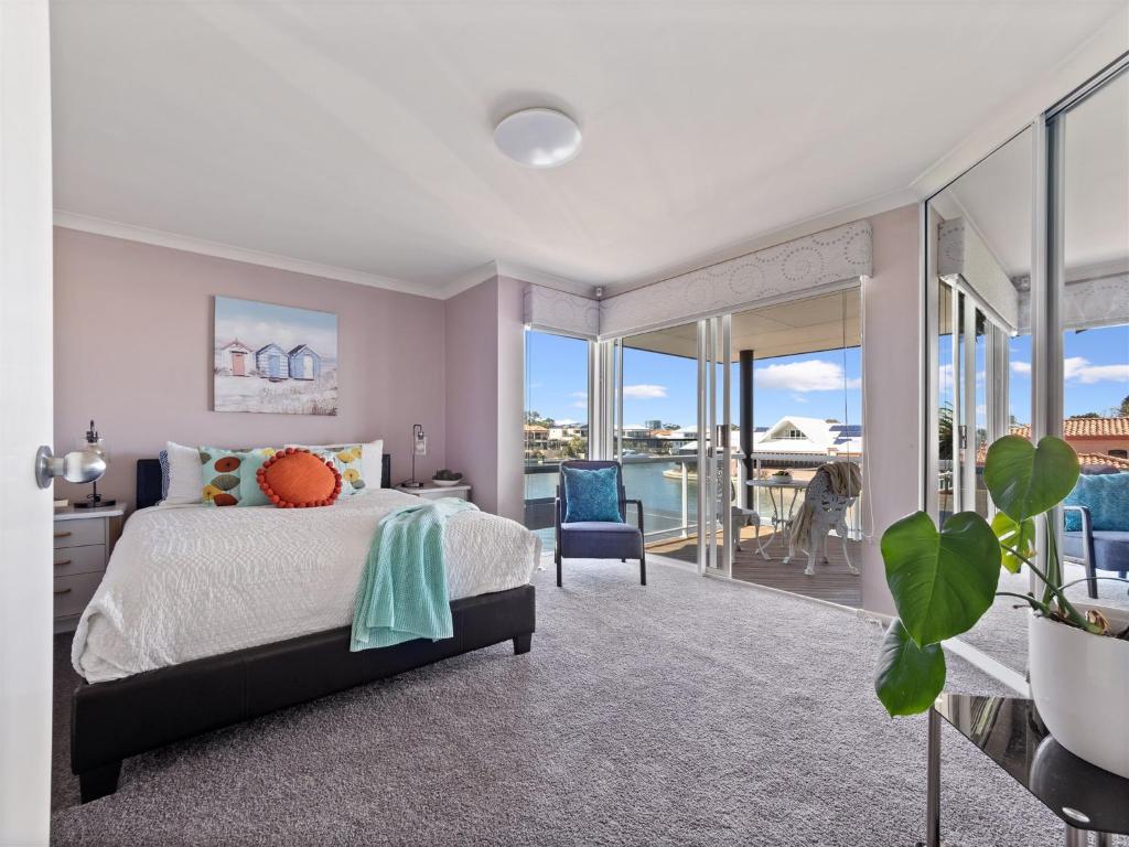 a bedroom with a bed and a balcony at Private Jetty -family & Pet Friendly in Mandurah
