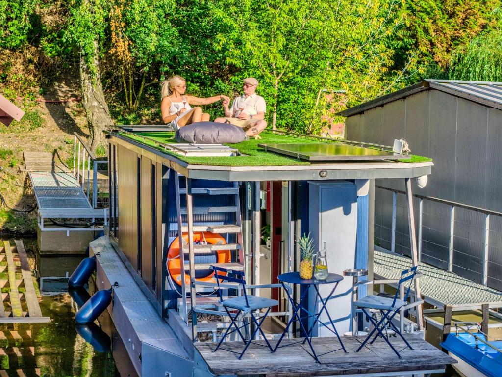 a man and a woman sitting on a house boat at Houseboat Prague with Paddle Boat -Sail, Explore and Relax in Prague