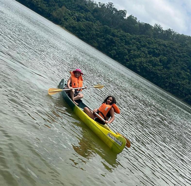 two people in a kayak on a body of water at Hotel Pousada Fazendinha in Nazaré Paulista