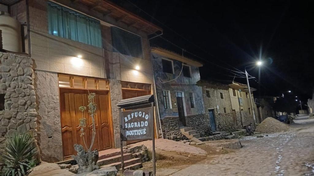 a sign in front of a building at night at Refugio Sagrado Boutique in Cusco