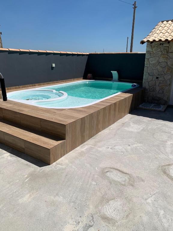 a swimming pool with a bench around it at Casa de praia Lar abençoado! in Cabo Frio