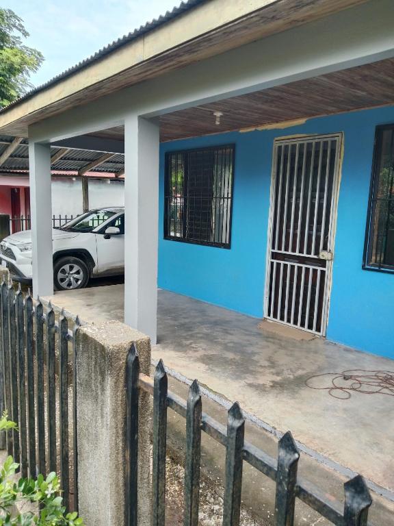 a blue house with a car parked in front of it at Pacific villa lisn in Nicoya