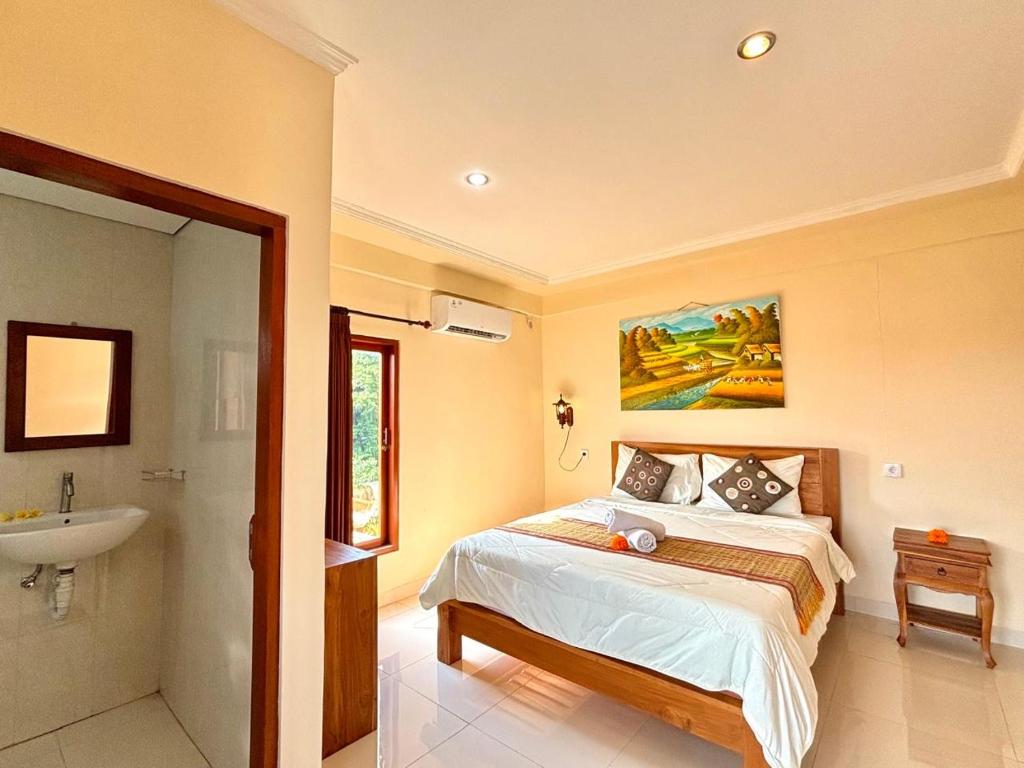 a bedroom with a bed and a sink at Wahadi homestay in Ubud