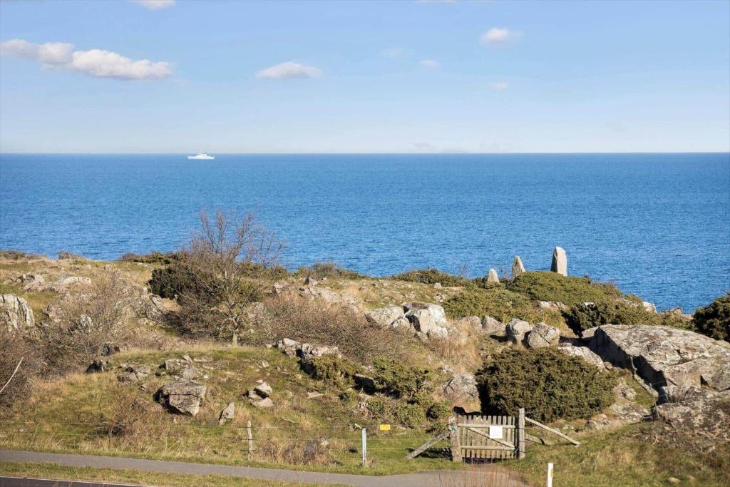 a view of the ocean with a boat in the distance at 5579-Gudhjem-Sdr-Strandvej-128-1-lejl-17 in Gudhjem