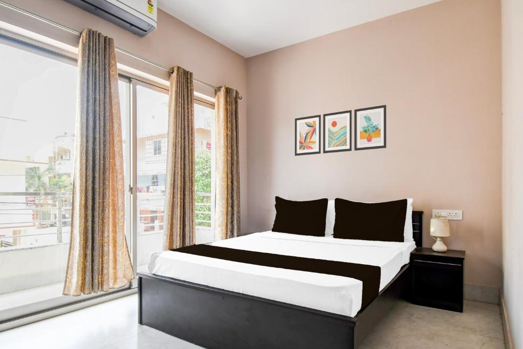 a bedroom with a bed and a large window at Hotel O Aasiyanaa Guest House in Bhubaneshwar