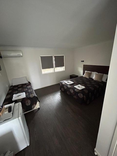 a room with two beds in a hotel room at Coal n Cattle Hotel Motel in Moura