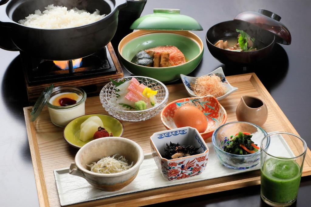 une table sur laquelle sont posés des bols de nourriture sur un plateau dans l'établissement Soratoniwa Atami Izusan, à Atami