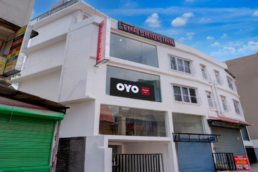 een wit gebouw met een ovo-teken erop bij Hotel O The Pride Inn Basistha Road in Khānāpāra