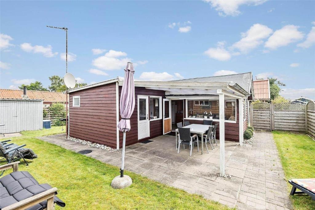 a house with a patio and an umbrella in the yard at SB53859-Broager-Pilevej-4 in Vemmingbund