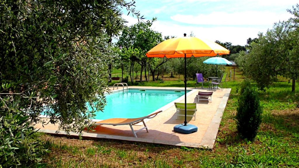 ein Pool mit einem gelben Regenschirm und einem Stuhl in der Unterkunft Apartments Garden Monsena in Rovinj