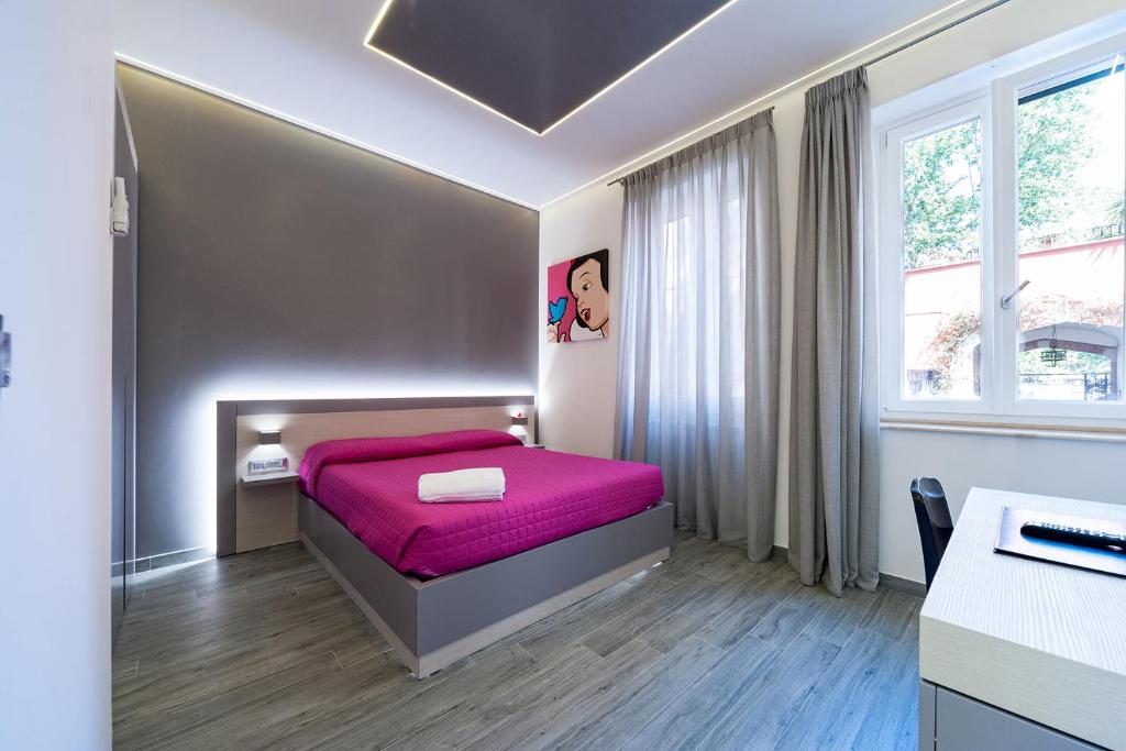 ローマにあるGuesthouse Popのベッドルーム1室(ピンクの毛布付きのベッド1台付)